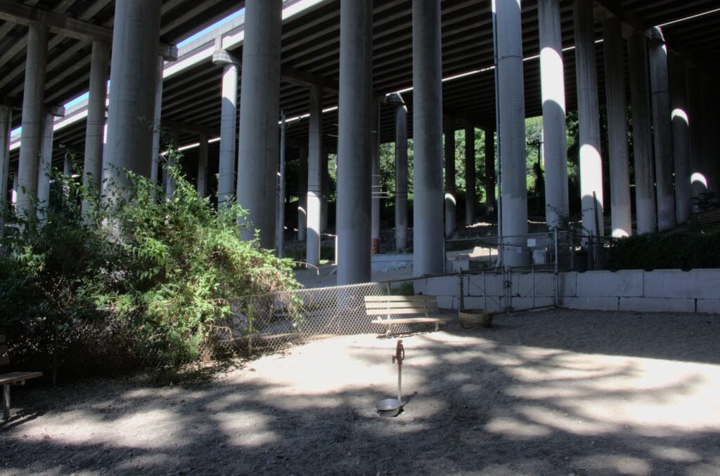 Pic of water spigot and bowl in dog park under highway