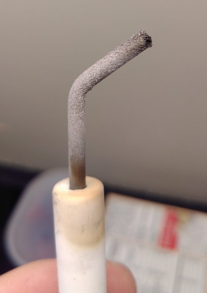 A igniter with a layer of white oxide powder all over it. 